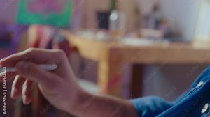 Professional male artist using stylus pen and digital tablet for drawing, working on a creative project in an art studio. Close-up shot