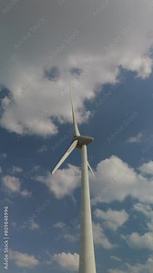 windmill turbine in the clouds and a blue sky, windmill turbines generate green energy in the ocean. Energy transition in the Netherlands Europe