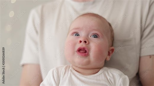 Adorable baby with blue eyes looking up with a curious expression and drooling slightly