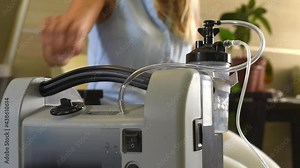 Oxygen breathing machine nuvo nidek using at home. Hand of person to adjust power of air. Breathing device for asthma and coronavirus. For old people with problem lungs. Stock Video