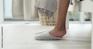 Morning, woman putting her slippers on and after getting out of her bed in her bedroom at home. Comfortable or warm, feet and female person put on her soft house shoes or footwear at her house