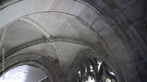 Pan across rib vaulted ceiling and gothic window tracery.