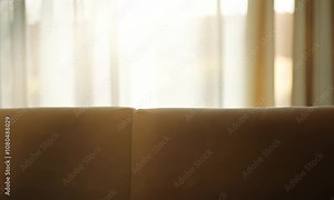 Blur abstract background of sofa in living room at big window with bokeh sunlight