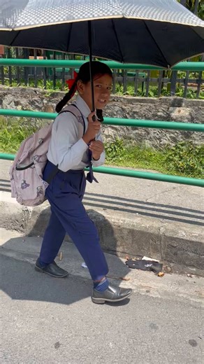 Okay, I am taking your question as an opportunity to delve a little bit into the recent history of education in Nepal and recount my own school days.What she's wearing is not exactly a suit but a standard private-school uniform in Nepal: a formal white shirt, slacks (or a pleated skirt), navy socks, black shoes, and a tie and belt with a pattern or badge unique to your school. For winter, there may also be an optional blazer (with metal buttons) that'll make this uniform feel more formal. Such a