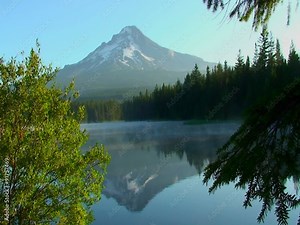 Steam rises from Trillium Lake which is surrounded by pine trees near Mt. Hood in Oregon.