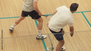 Two guys playing squash at the court