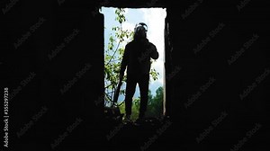 A mysterious guy approaches the window of an abandoned house. He looks inside the house Stock Video