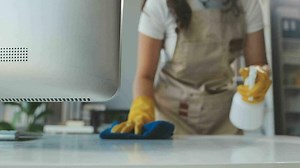 Housewife using vacuum cleaner on the floor. Wearing an apron to clean the living room at house. Young woman is happy to clean home. Maid cleaning service.