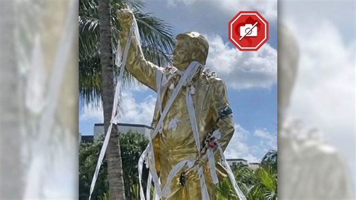 Was golden Trump statue vandalized with garbage, as shown in image?