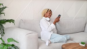 Side view on happy young student african americSide view on happy young student african american girl at home scrolling through social media,videos etcan girl at home using phone for downloding study
