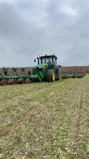 JOHN DEERE TRACTOR PLOWING A FIELD WITH A DOUBLE MACHINE PLOW