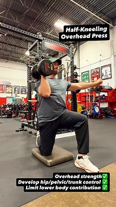 Half-kneeling is my go-to way to start overhead pressing with clients. With one knee down in a split stance, you can’t cheat your way through the rep. The position forces you to control pelvic, trunk, and hip stability while staying tall and centered under the load. It’s a self-limiting position where you immediately feel excessive side bending, rotation, or extension because the stance gives you built-in feedback. Half kneeling stance removes assistance from the lower body, forcing the client t