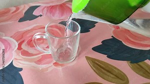 Pouring water from a pitcher with a filter into a transparent mug