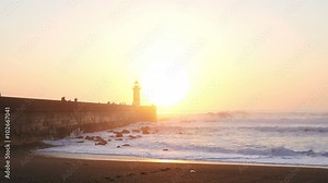 Lighthouse Felgueirasin Porto with waves and sun at sunset