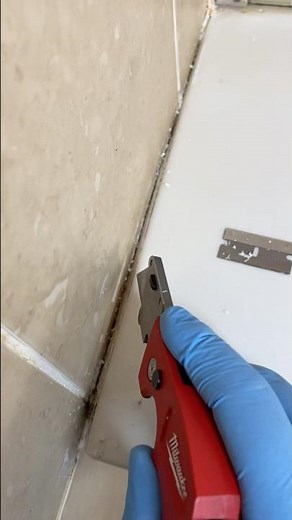 Using a razor blade and mini screwdriver to remove caulking from shower. #diy