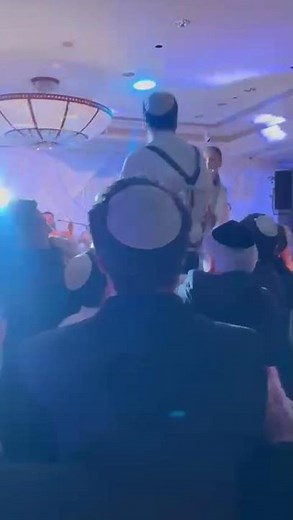 ￼Traditional dancing at Jewish wedding bride and groom on chairs