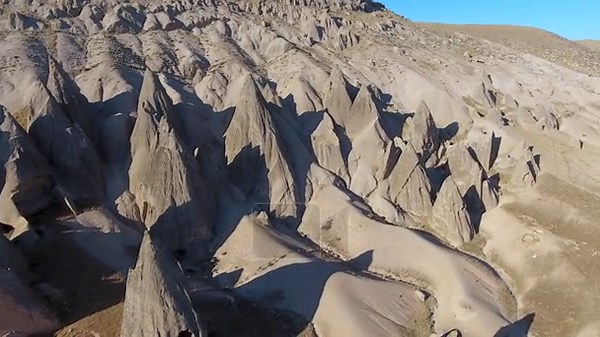 Aerial drone view of Cappadocia fairy chimneys and sculpted volcanic valleys in Turkiye. Unspoiled tuff badlands reveal surreal rock pinnacles cave dwellings and erosional landforms across Anatolia. cappadocia, drone, chimneys, turkiye, valley Stock Video Footage - Alamy
