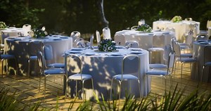 Elegant outdoor dining setup with white tables and floral centerpieces
