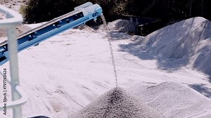 Conveyor belt distributing crushed stone creating mounds in a mining quarry