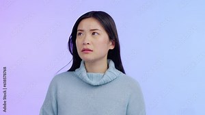Asian woman, thinking and anxiety on face with worried, fear and anxious feeling isolated in a purple studio background. Upset, anxiety or sad model and person with depression, crisis or trauma