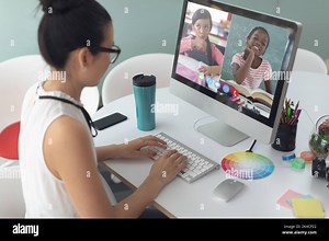 Asian woman using computer for video call, with smiling diverse elementary school pupils on screen. communication technology and online education, dig Stock Photo - Alamy