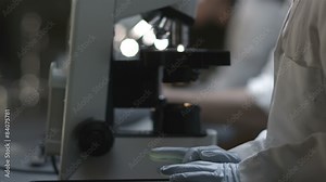 University Students in a chemistry lab look through a microscope for experiments