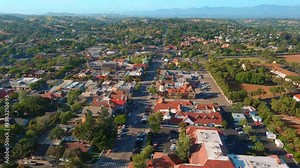 Smooth aerial zoom in revealing the charming architecture and urban layout of Solvang, a Danish-inspired town in Southern California during spring.