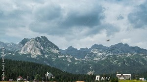 Houses of Zabljak village and peaks of Durmitor mountains with pine trees, Montenegro. Timelapse 4K.