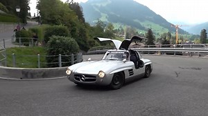Gullwing Mercedes cruising through mountains with door open