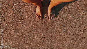 A woman on the beach of the Sea of Azov. Background of sea waves from the beach. A foaming wave. Relaxing by the sea. Shell beach. Footsteps on the seawater. 4K