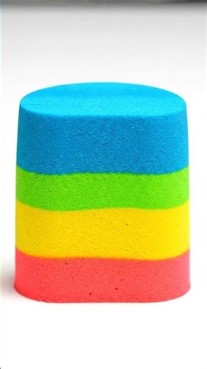 Vibrant multi-layered kinetic sand block being precisely