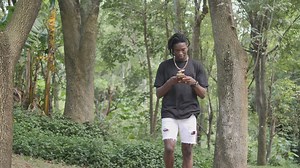 Man texting on cell phone while walking in park - Free Stock Video