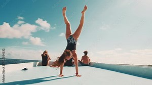Flexible woman does gymnastics on the roof of a moving boat in tropics