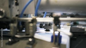 Close up of a printing plant machine insides with wires and gears during its work process. Left to right pan real time close up shot