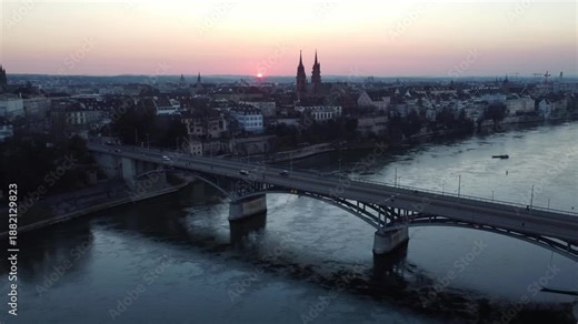 Basel, Switzerland: Aerial drone footage of a dramatic sunset over Basel old town, the Wettstein bridge and the Basel Munster, the gothic cathedral in Switzerland