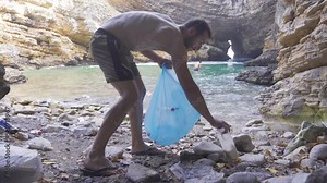 Garbage Collection in Coastline.Cleaning nature from garbage. The young man in the sea bay collects the garbage thrown around. Stock Video