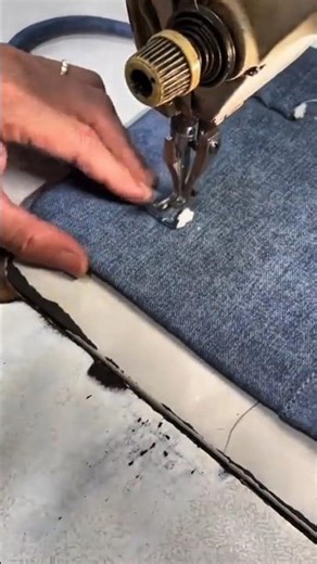 sewing blue denim fabric pieces together using a manual industrial lockstitch sewing machine tool