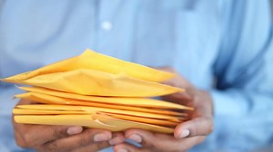 hand hold yellow paper bubble envelope
