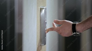 Man's hand push the elevator button