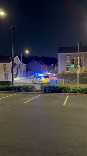 Police Chase Car Through City Streets at Night