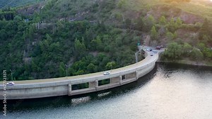 Drone flying over water reservoir, passing the barrage, dam, revealing the abyss