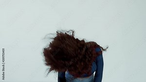woman with long curly hair dancing and shaking hair and smiling. Have fun shaking head