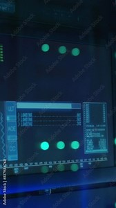 Close up vertical shot of computer monitor screen with user interface in server racks in a modern data center display computing processes and network state.