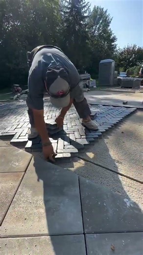 Arranging interlocking bricks to create a patterned outdoor pavement #construction #popular #skills