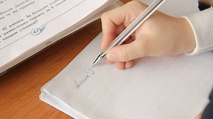 Student hand writes notes in a notebook - Free Stock Video