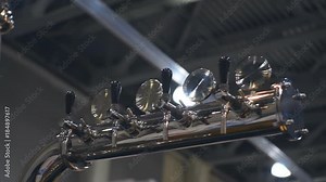 Beer rack with chrome-plated faucets for pouring a foamy drink shine in the light. Shot in motion