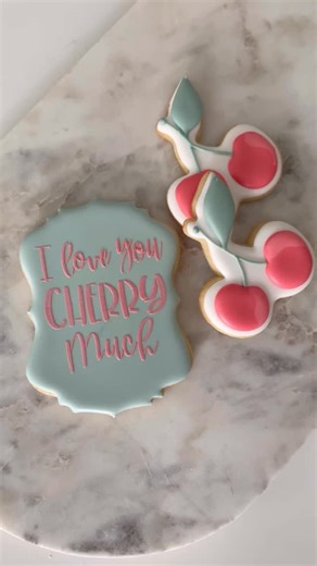 Annamaria Valentino || Mary on Instagram: "“I love you cherry much” COOKIES!🍒🍒 If you’re not comfortable piping script on cookies, we have a bunch of script stencils available to simplify the process! Using a medium to stiff consistency to scrape over your stencil is important to achieve the result you see in this video. If the icing is too thin, it will seep under the stencil and smudge. The Sweet Stencil Holder is an amazing tool to keep your stencil securely in place while you’re stenciling