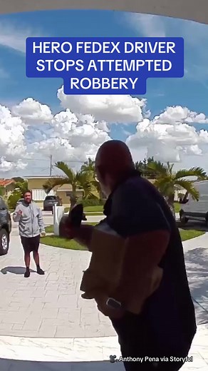 A FedEx driver has been hailed as a hero after stopping what appears to be an attempted theft while delivering a package. Security video shows the driver walking towards the home when a man approaches him. When the man failed to respond, the driver said 'no, no, I don’t know you, I’m going to call the police,' shaking a finger in his face. The man then fled the scene, allowing the worker to safely deliver the package. 🎥 Anthony Pena via Storyful #news #hero #heartwarming #ring