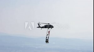 People hanging from helicopter performing stunt flying.Aerobatics flying Rope people dangerous danger hazardous man men male soldier army sagging crazy training, recreation, entertainment, sport 4K