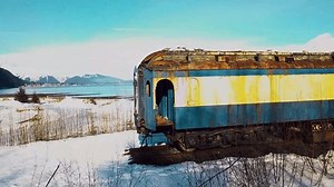 雪の降る冬の日にアラスカ州セワードでアラスカ鉄道列車の廃車の4Kドローンのビデオ